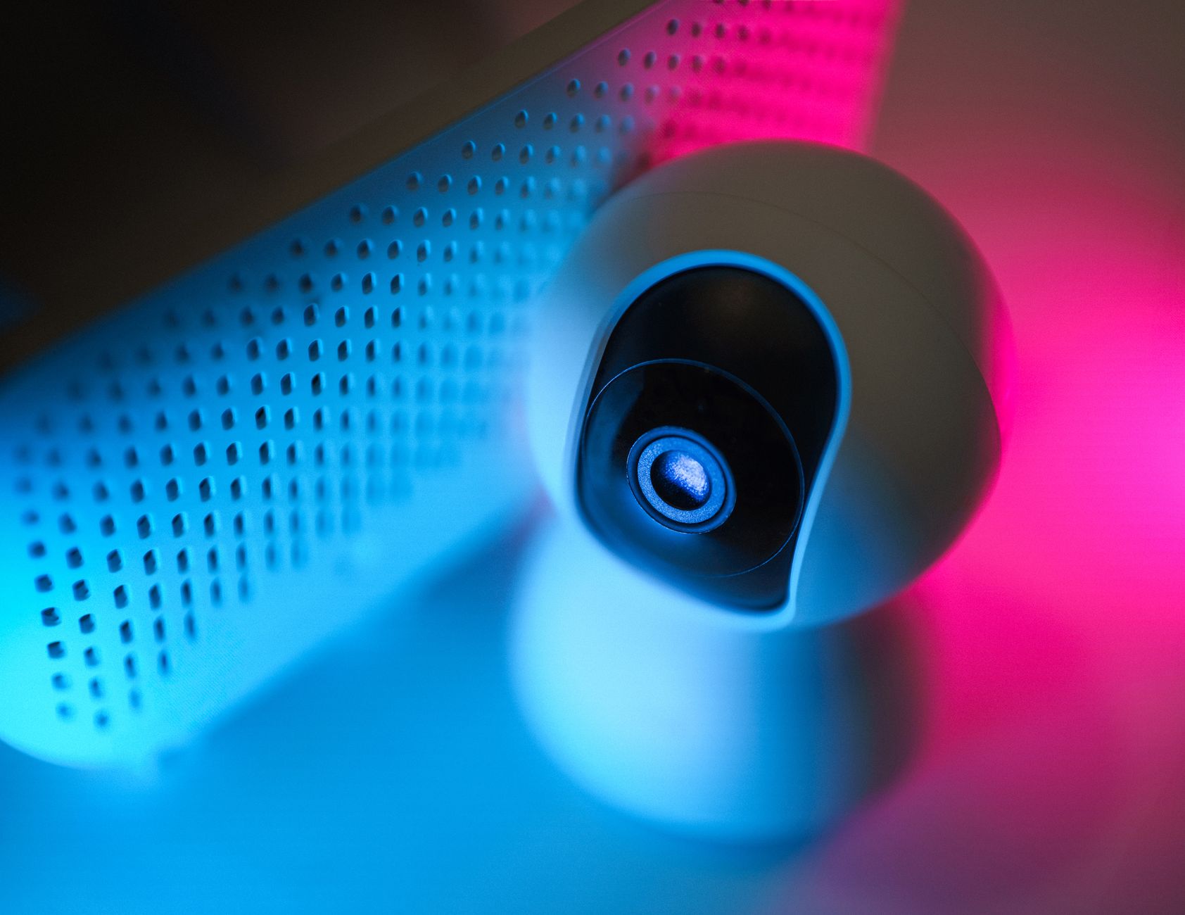 Szyfrowanie w IoT: jak zabezpieczyć inteligentny dom przed podsłuchem i przejęciem Zbliżenie kamery monitoringu w neonowym świetle, zabezpieczenia smart domu